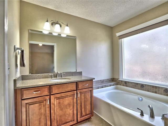 bathroom featuring tile patterned flooring, a textured ceiling, vanity, and a bath