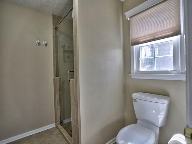 full bathroom with tile patterned floors, a shower stall, and baseboards