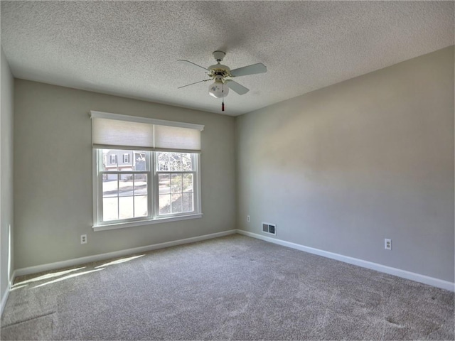 spare room featuring visible vents, carpet flooring, baseboards, and ceiling fan