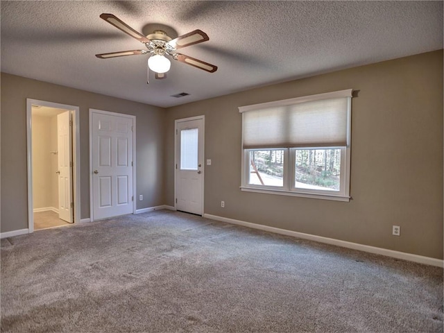 spare room with visible vents, baseboards, a ceiling fan, and carpet flooring