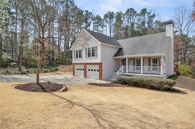 split level home featuring driveway, roof with shingles, covered porch, a chimney, and a garage