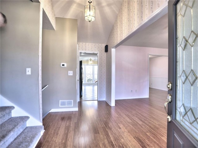 entrance foyer with visible vents, baseboards, wood finished floors, and wallpapered walls