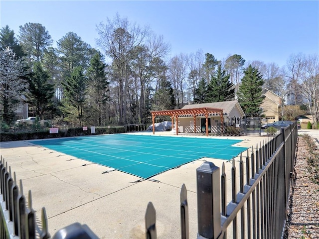 community pool with a patio area, a pergola, and fence