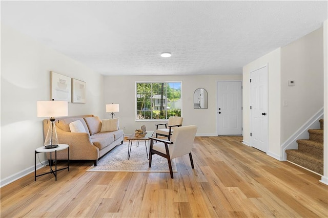 1275 Muirforest Way, Stone Mountain, GA 30088 - living room featuring stairs, baseboards, light wood-style floors, and a textured ceiling