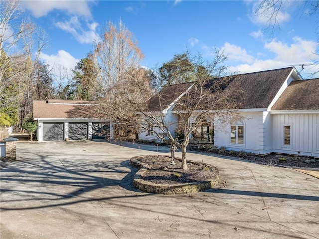 view of front of house with a shingled roof and curved driveway