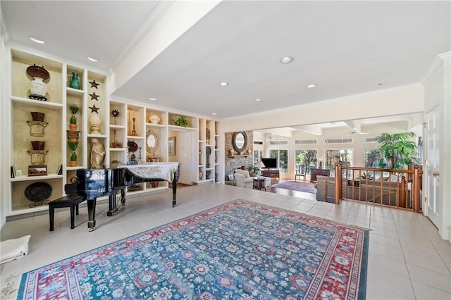 sitting room featuring a ceiling fan, tile patterned flooring, crown molding, and built in shelves