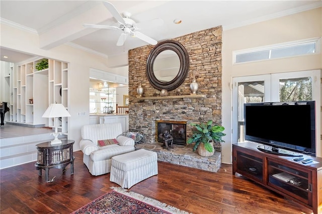 living room featuring crown molding, a fireplace, ceiling fan, and wood finished floors