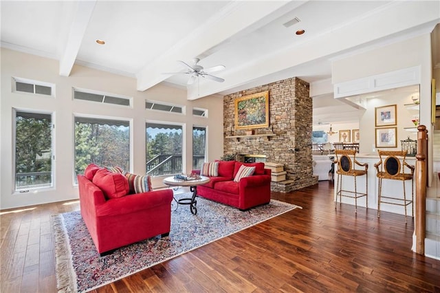 living room featuring beam ceiling, a fireplace, visible vents, a ceiling fan, and hardwood / wood-style flooring