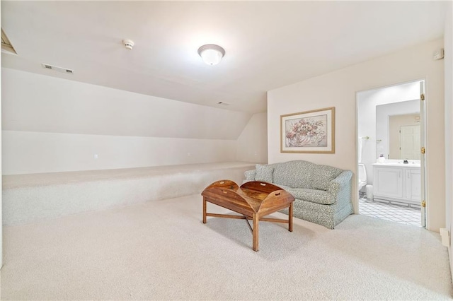 sitting room featuring lofted ceiling, carpet, and visible vents