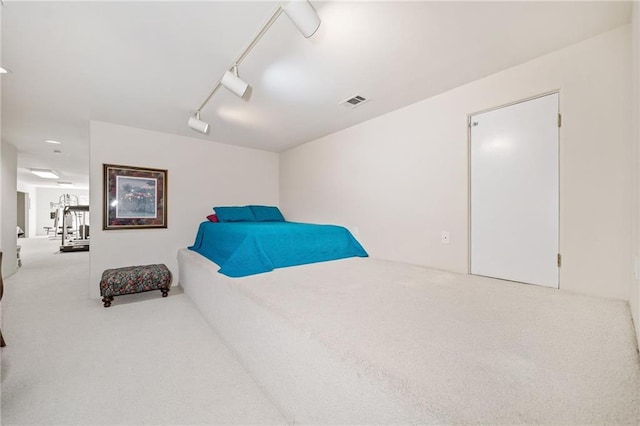 bedroom featuring carpet floors, rail lighting, and visible vents