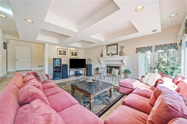 living area with recessed lighting, a glass covered fireplace, visible vents, baseboards, and a raised ceiling