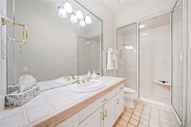 full bathroom featuring a shower stall, toilet, and vanity