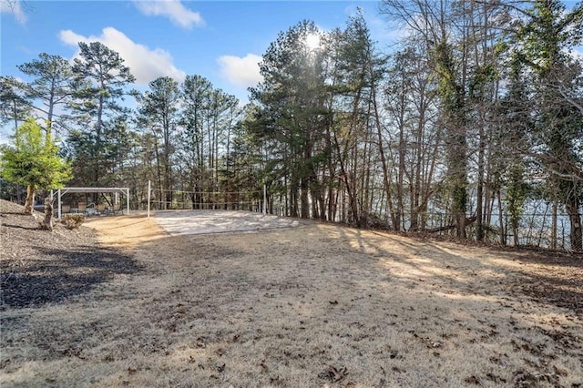 view of yard with volleyball court and fence