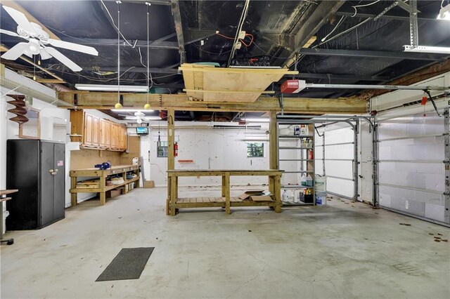 garage with a garage door opener, a workshop area, and ceiling fan