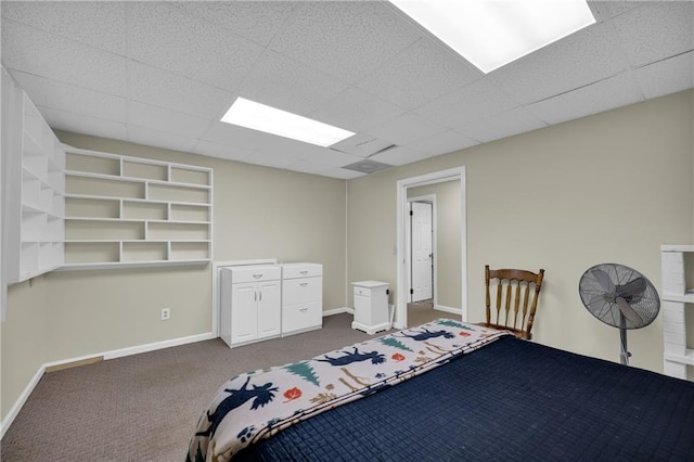 bedroom with dark colored carpet and a paneled ceiling