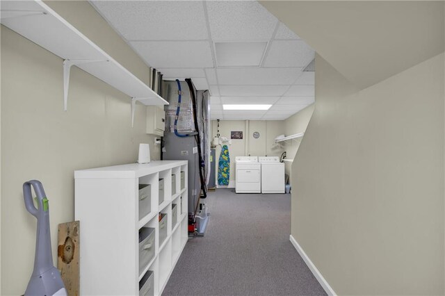 interior space with a drop ceiling, dark carpet, and separate washer and dryer