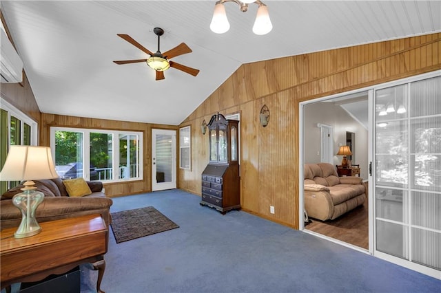 living room with dark colored carpet, wood walls, ceiling fan, and vaulted ceiling