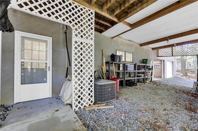 miscellaneous room with concrete flooring and beamed ceiling