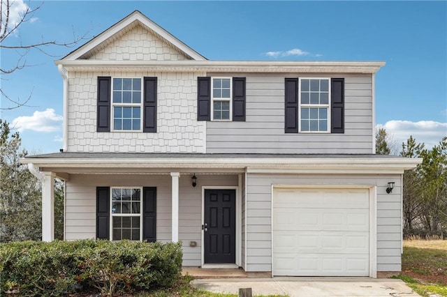 traditional-style house featuring a garage and concrete driveway