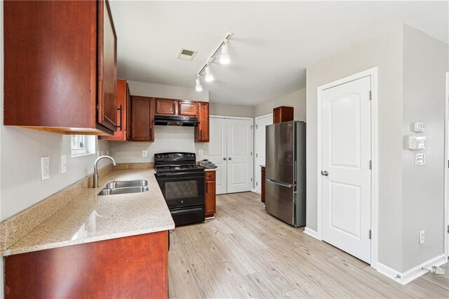 kitchen featuring visible vents, freestanding refrigerator, black electric range, under cabinet range hood, and a sink