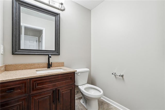 half bath with toilet, tile patterned flooring, vanity, and baseboards