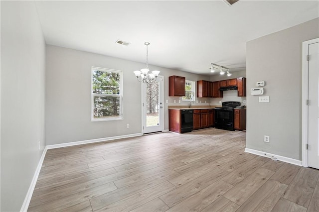 kitchen with a notable chandelier, visible vents, light wood-type flooring, under cabinet range hood, and black appliances