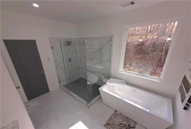 bathroom featuring separate shower and tub