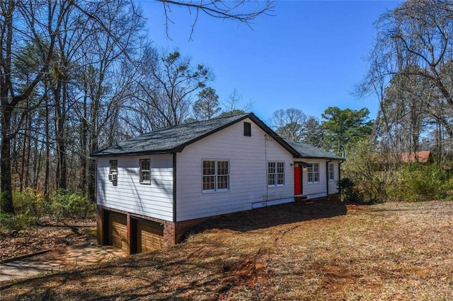 view of side of property featuring dirt driveway