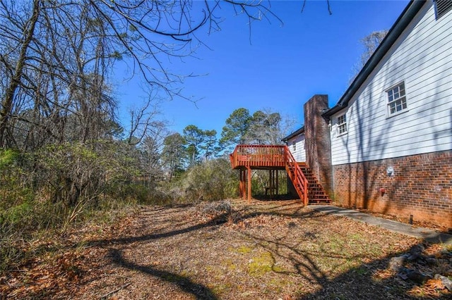 view of yard with a deck and stairs