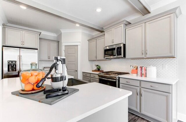 kitchen with beamed ceiling, decorative backsplash, and stainless steel appliances