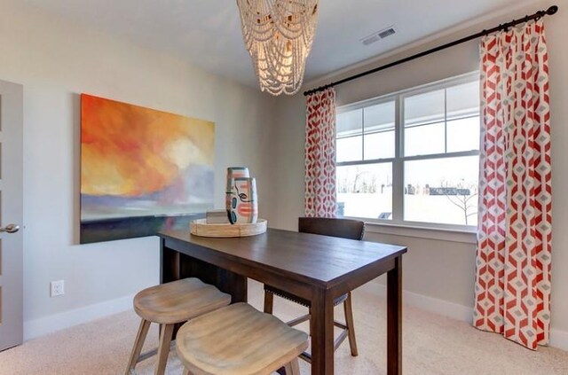 dining area with a chandelier and light colored carpet