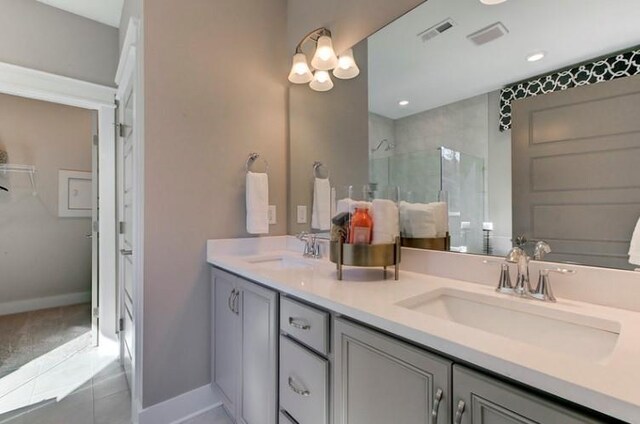 bathroom with tile patterned flooring, vanity, and an enclosed shower