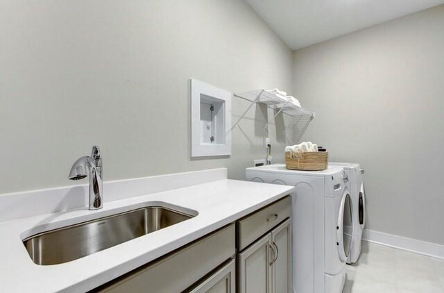 clothes washing area with cabinets, independent washer and dryer, and sink