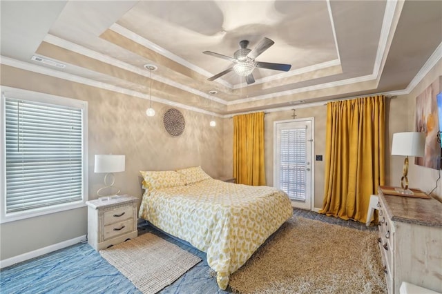 bedroom with crown molding, a tray ceiling, multiple windows, and baseboards