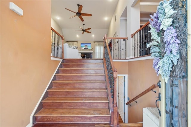 stairs with ceiling fan, visible vents, a towering ceiling, and recessed lighting