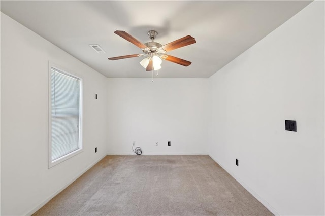 spare room featuring ceiling fan, visible vents, and light colored carpet