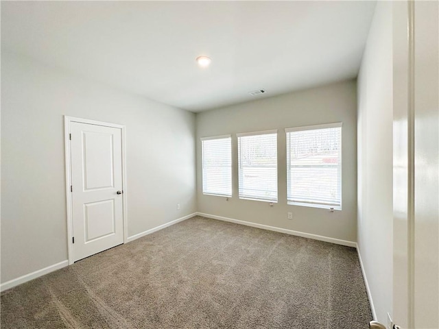 carpeted empty room with visible vents and baseboards