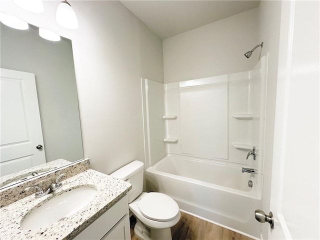 bathroom featuring shower / washtub combination, toilet, vanity, and wood finished floors