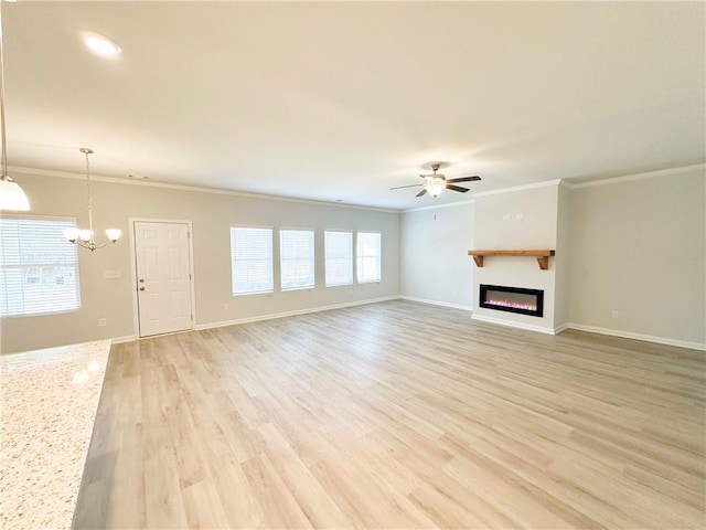 unfurnished living room featuring crown molding, baseboards, ceiling fan with notable chandelier, light wood-style floors, and a glass covered fireplace