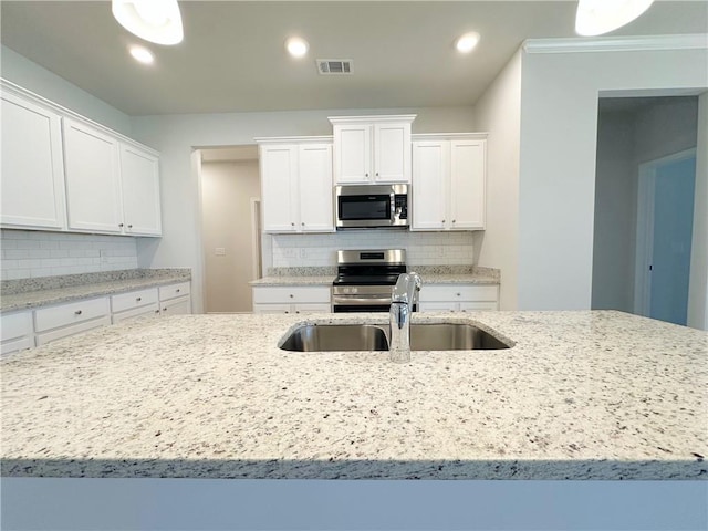 kitchen featuring a sink, visible vents, appliances with stainless steel finishes, and white cabinetry