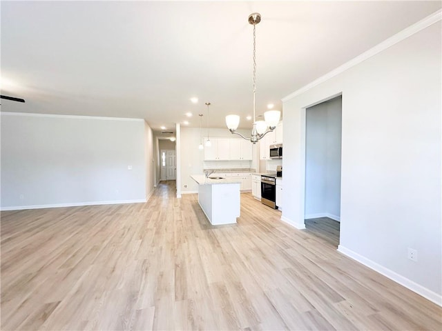 kitchen featuring open floor plan, crown molding, stainless steel appliances, and light countertops