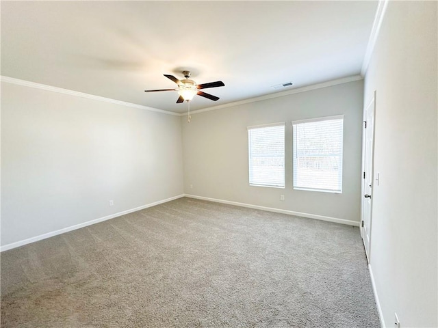 carpeted spare room with visible vents, baseboards, ornamental molding, and a ceiling fan