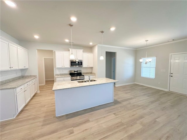 kitchen featuring baseboards, a sink, appliances with stainless steel finishes, light wood-type flooring, and backsplash