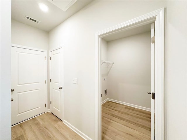 washroom with baseboards, visible vents, and light wood finished floors