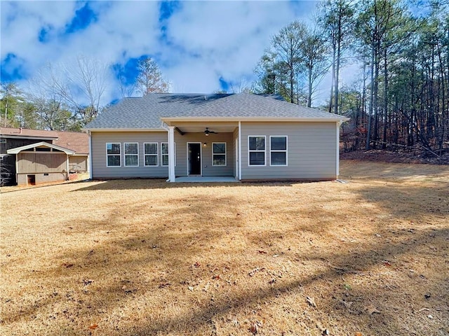 ranch-style home with a patio area, a front yard, a ceiling fan, and roof with shingles