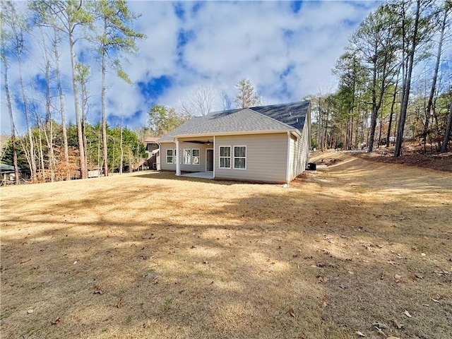 back of property with a lawn and a ceiling fan