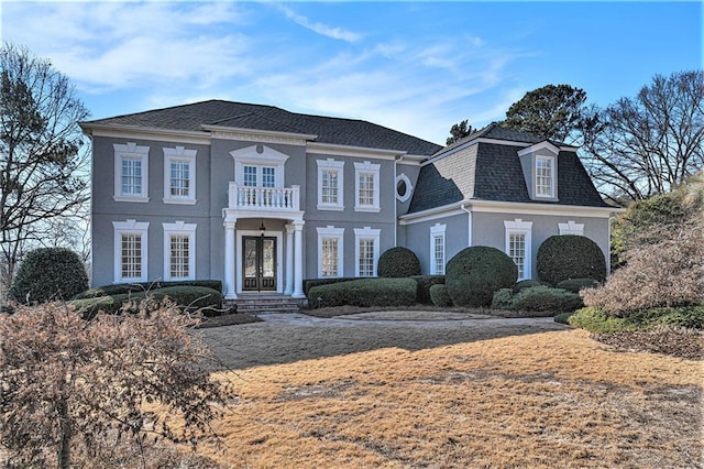 view of front of home with french doors and a balcony