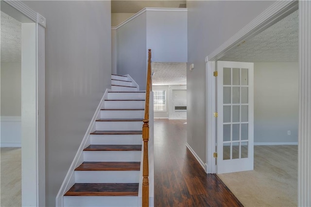 staircase with wood-type flooring and a textured ceiling