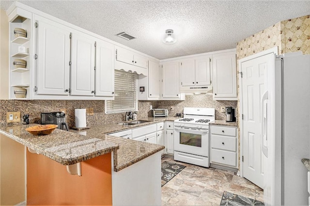 2130 Hampton Trl SE, Conyers, GA 30013 - kitchen featuring white appliances, a peninsula, under cabinet range hood, white cabinetry, and a textured ceiling
