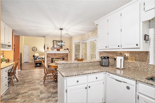 2130 Hampton Trl SE, Conyers, GA 30013 - kitchen featuring dishwasher, a peninsula, a fireplace, white cabinetry, and a textured ceiling
